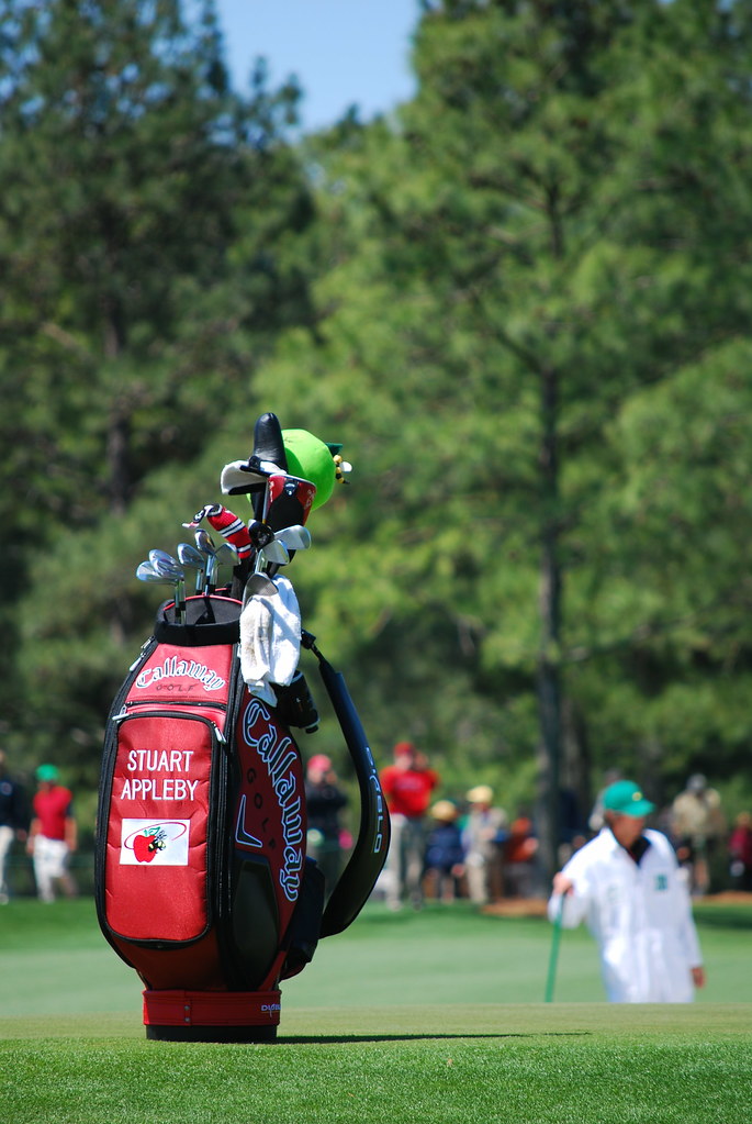 A man carrying a bag of golf equipment."